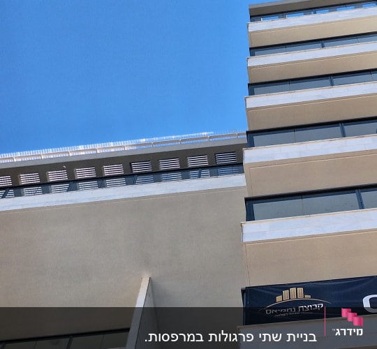 בניין גבוה עם מרפסות ושלט פרסום